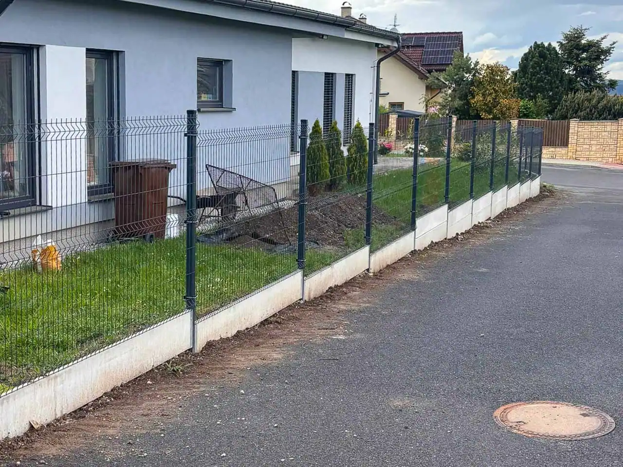 Antracitové 3D plotové panely s podhrabovými deskami u rodinného domu, realizace Hořovice 2026